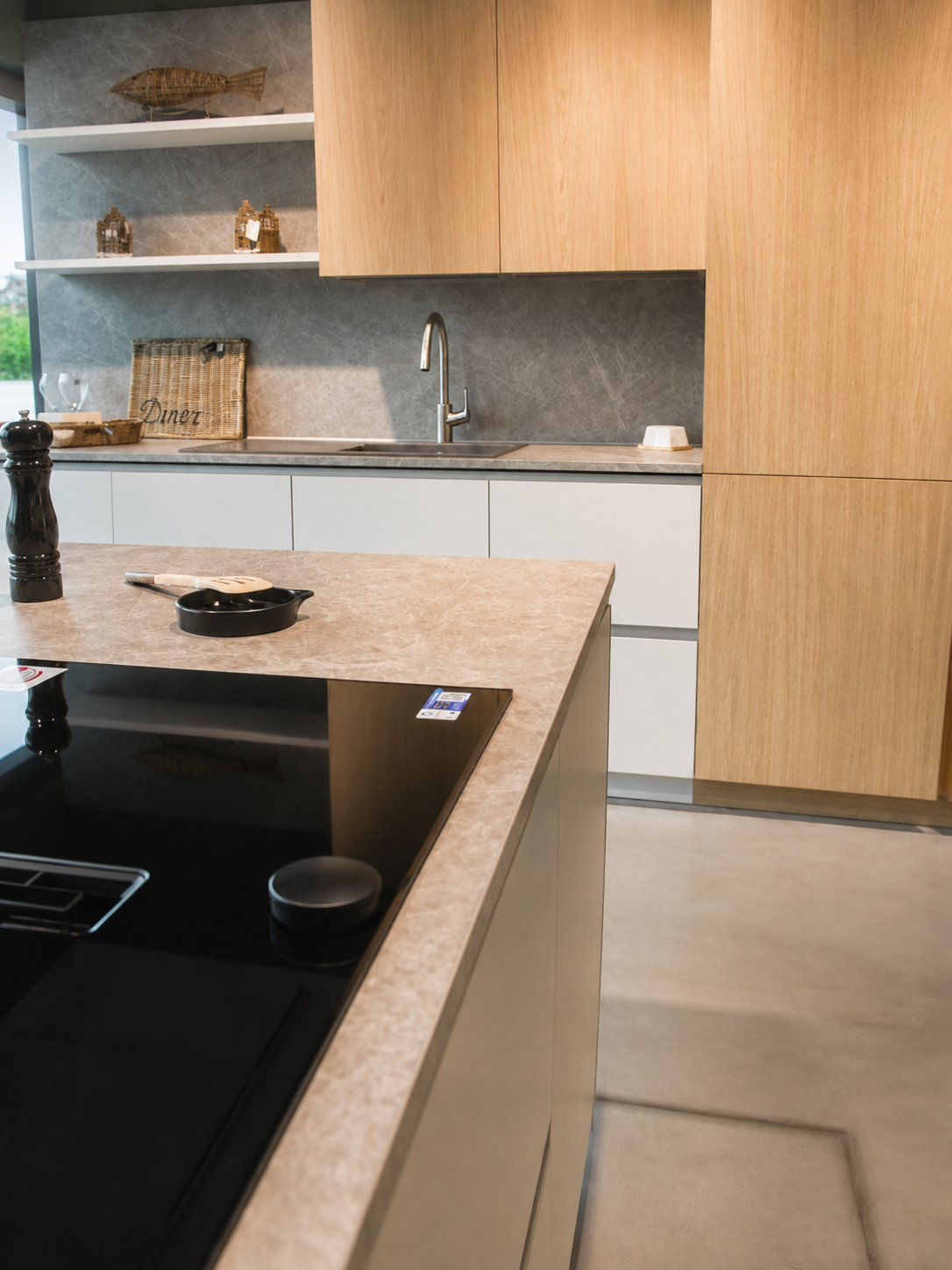 Moderne Musterküche mit Kochfeld, hellen Holzfronten und Spülbereich im Küchencentrum Holtmann in Bückeburg